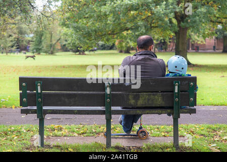 A loving moment between a father and son on a park bench Stock Photo