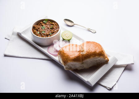 Kheema / keema Pav or Khima Paav is a spicy curry dish made up of minced chicken or lamb cooked with onion, tomatoes, served with buns. selective focu Stock Photo