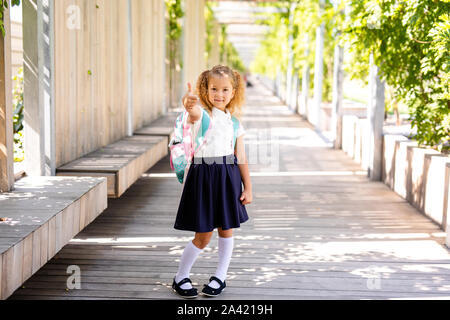 portrait of school kids running on the way in park (focus on the girl) Stock Photo