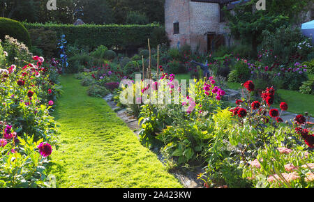 The Sunken garden at Chenies, Buckinghamshire on a sunny evening in September;the restored Pavilion.Colourful dahlia varieties and bright grassy path. Stock Photo