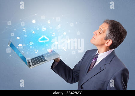 Man holding laptop projecting notifications, symbols and information based on cloud technology system Stock Photo