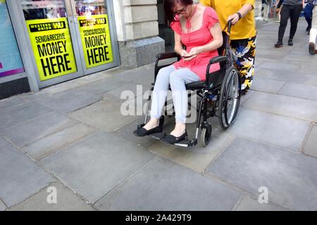 London, England, UK. Woman in a wheelchair using her mobile phone Stock Photo