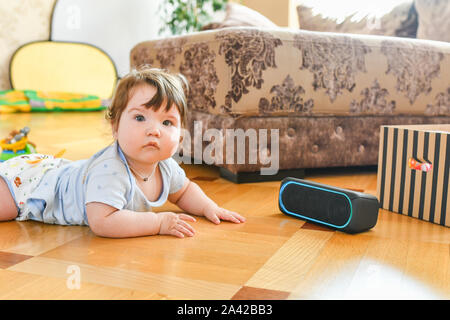 the child listens to a portable speaker system. listening to music from an early age Stock Photo