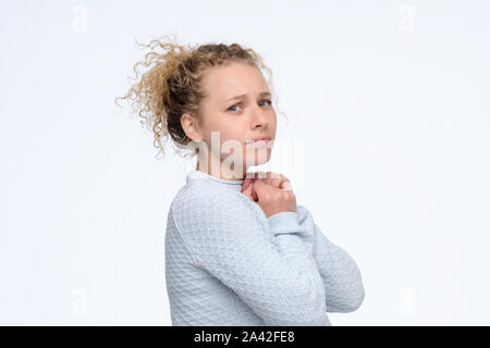 Young curly disappointed woman looking at camera. Stock Photo