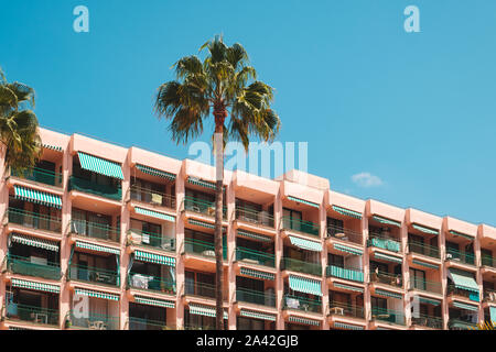 vacation rental apartment building balconies and palm tree on sunny day Stock Photo