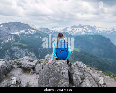 Woman sitting on top of a mountain Stock Photo