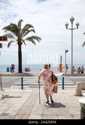 Staden Nice på den franska rivieran. Dam på väg till den stora stenstranden i centrala Nice. The city of Nice on the French Riviera. Lady on the way to the big pebble beach in central Nice.Foto Jeppe Gustafsson Stock Photo
