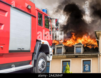 Fire service with burning house Stock Photo