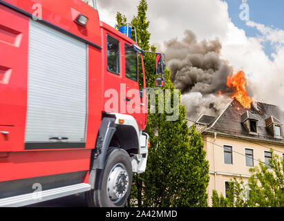 Fire service with burning house Stock Photo