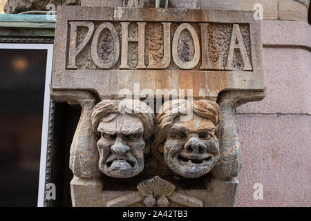 Carved scowling faces on a building in central Helsinki, Finland Stock Photo