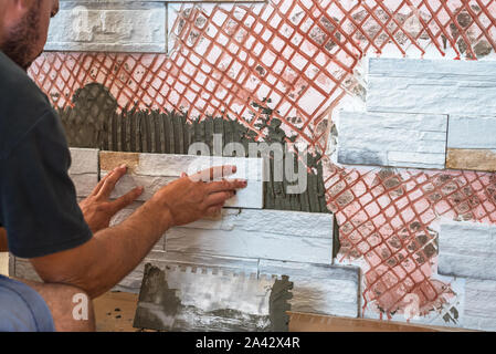Installing the tiles on the wall. Stock Photo