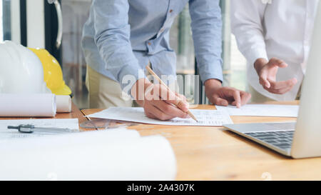 Image of engineer meeting for architectural project working with partner and engineering tools on workplace. Stock Photo