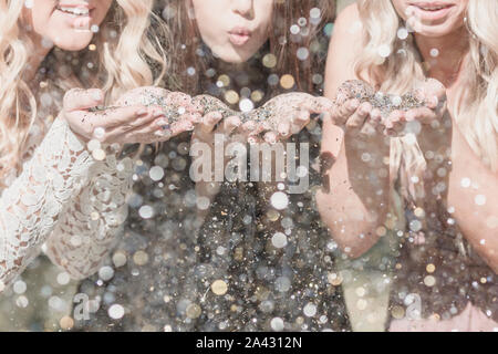 Three young women blow glitter in college graduation celebration Stock Photo