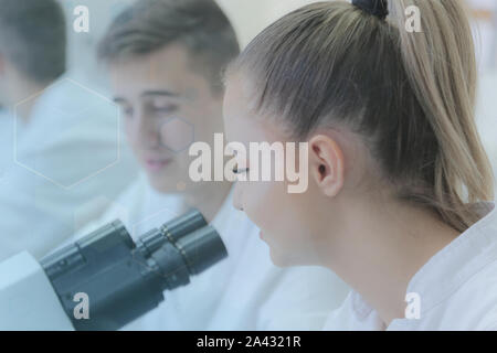 Two young male and female students scientists doing experiments in laboratory. Stock Photo
