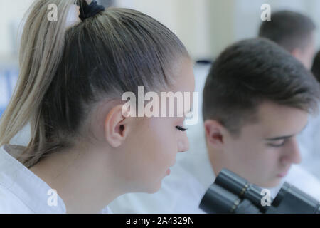Two young male and female students scientists doing experiments in laboratory. Stock Photo
