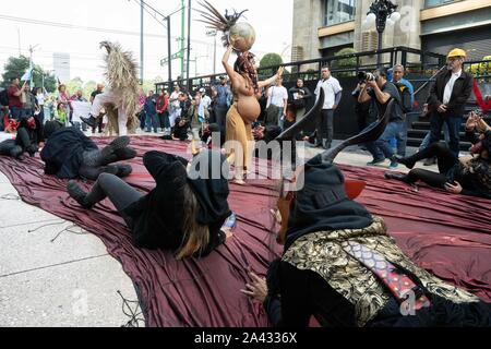 A woman is seen wearing an outfit to represent fertility and pregnancy.  People are seen dancing on Calle Madero in the centre of Mexico City.  The dance is performed to represent Mother Earth and her fight against the elements. Lexie Harrison-Cripps Stock Photo