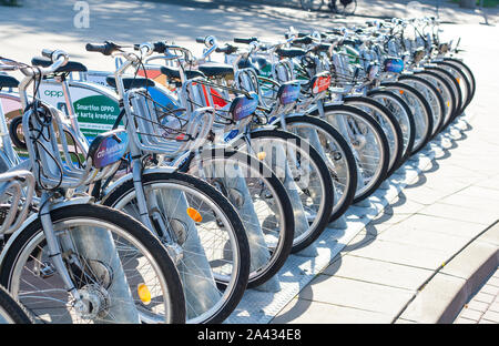 Warsaw, Poland: City bicycles parked in a row on bicycle parking - seen plaques with advertisements Stock Photo