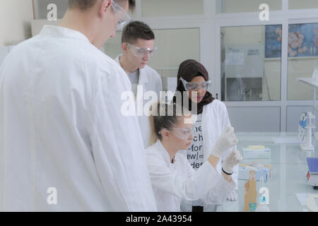 Group of young  scientists doing experiments in laboratory Stock Photo