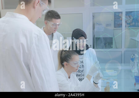 Group of young  scientists doing experiments in laboratory Stock Photo