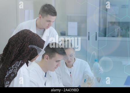 Group of young  scientists doing experiments in laboratory Stock Photo