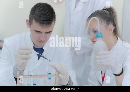 Group of young  scientists doing experiments in laboratory Stock Photo