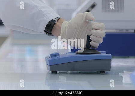 Technician loading a sample to centrifuge machine in the medical or ...