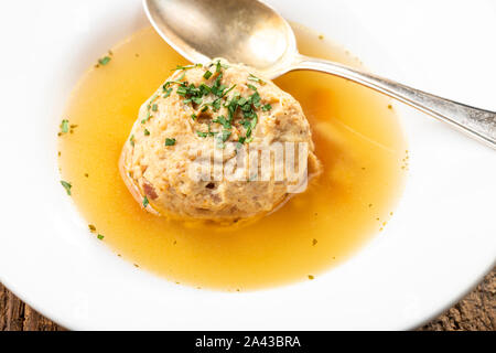 single speckknoedel in soup on wood Stock Photo