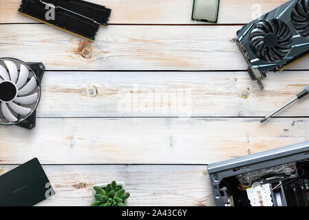 Build a gaming PC concept composition with conputer parts on wooden desk. Top view scene with free space in the middle for text. Stock Photo