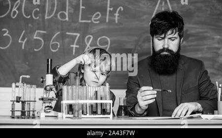 teacher man with little boy. school lab equipment. Back to school. father and son at school. using microscope in lab. student doing experiments with microscope in lab. Education is the ray of light Stock Photo