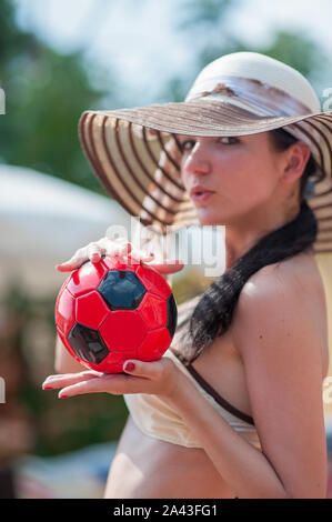 The girl is holding a red ball. Small ball in hand Stock Photo