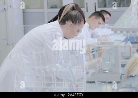 Weighting of ascorbic acid in chemical laboratory.Two multiethnic young female scientists doing experiments in laboratory. Stock Photo
