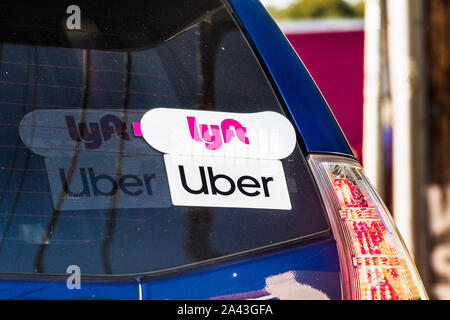 Oct 10, 2019 Mountain View / CA / USA - Lyft and UBER stickers on the rear window of a vehicle offering rides in San Francisco Bay Area Stock Photo