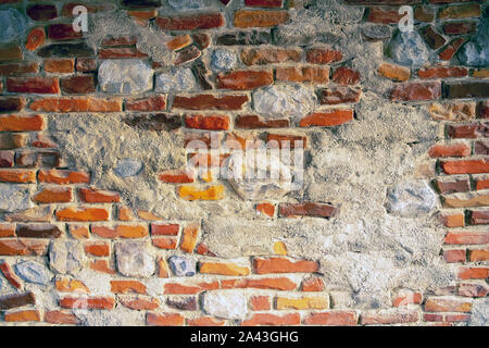 Wall of colorful bricks mixed with  light natural stones. Mixed bricks and concrete. Bricks background Stock Photo