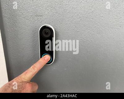 Orlando,FL/USA-10/10/19: A person pressing a Ring doorbell that has a motion sensor camera and is a smart home security company owned by Amazon. Stock Photo