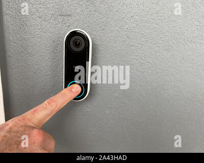 Orlando,FL/USA-10/10/19: A person pressing a Ring doorbell that has a motion sensor camera and is a smart home security company owned by Amazon. Stock Photo