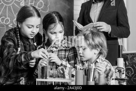 Inspired to work hard. happy children teacher. doing experiments with liquids in chemistry lab. chemistry lab. back to school. kids in lab coat learning chemistry in school laboratory. Stock Photo