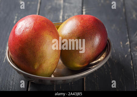 Mango fresh fruit on black wooden table. Stock Photo