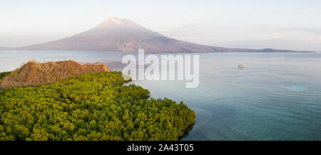 Sunrise illuminates the Iliape volcano found just east of Flores, Indonesia. This tropical area is part of the famous Ring of Fire. Stock Photo