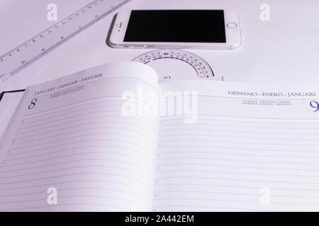 Open agenda next to a phone and rulers Stock Photo