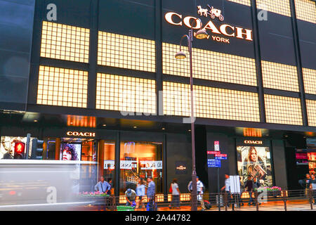 --FILE--Customers walk past a boutique store of Coach New York in Hong Kong, China, 5 November 2015.   American fashion brand Coach New York incurred Stock Photo