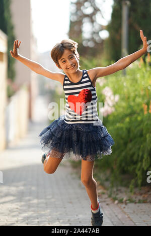 Little girl, eight years old, jumping outdoors. Stock Photo