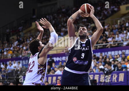 A basketball player of Greece, right, prepares to shoot while defended by a member of Venezuela, left, during 2019 Suzhou International Basketball Cha Stock Photo