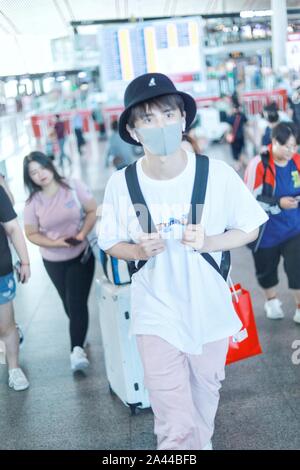 Chinese actor and singer Zhang Yuan, front white, arrives at the Beijing Capital International Airport before departure in Beijing, China, 18 August 2 Stock Photo