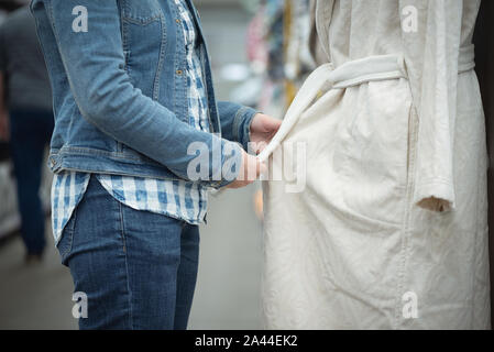 Woman choosing a new bathrobe in a store. Stock Photo