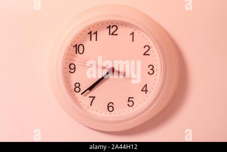 Round wall clock on the white wall Stock Photo