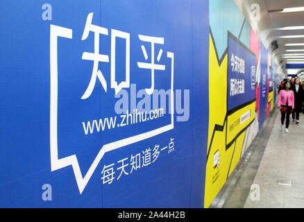 --FILE--Local residents walk past an advertisement for China's largest question-and-answer platform Zhihu in Nanjing city, east China's Jiangsu provin Stock Photo