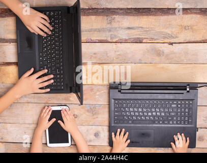 children sitting at the computers, holding tablet Stock Photo