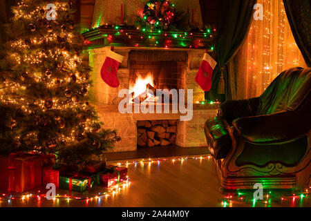 Interior of dark living room with Christmas wreath, fireplace and fir ...