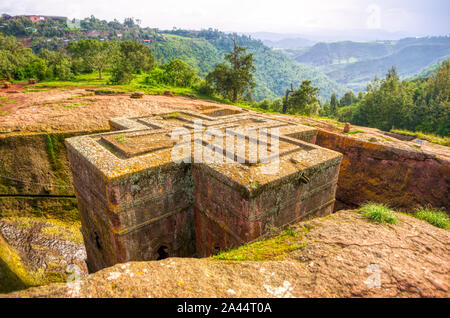 The churches of Lalibela excavated excavated in the bedrock with the cross of San Jorge. The incident light reflects the ocher, yellow and green chara Stock Photo