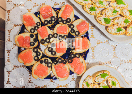 Different types of canapes on buffet table Stock Photo